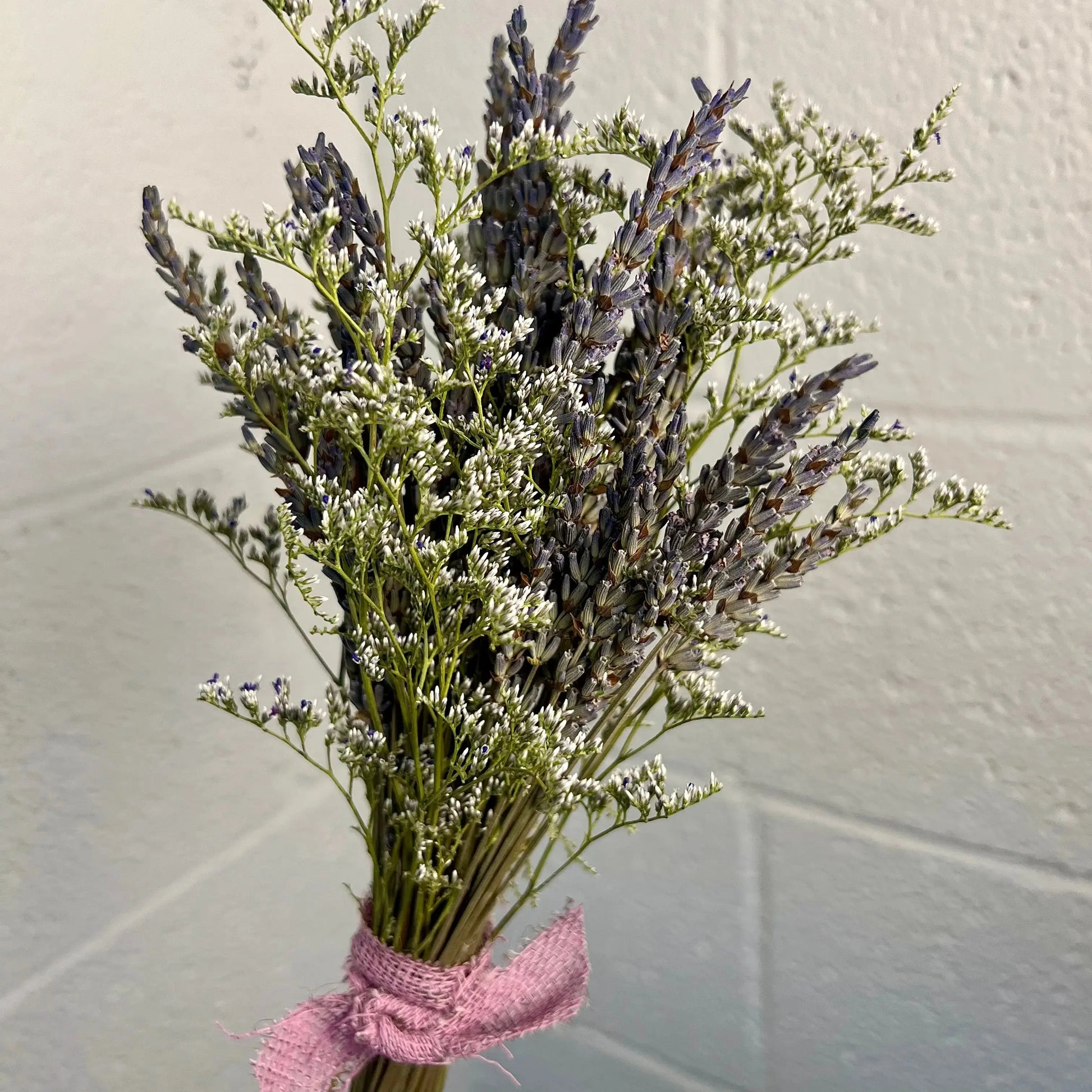 Bouquet of lavender with a pink ribbon on a light background